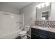 Well-lit bathroom with a bathtub, toilet, and a vanity with stylish mosaic backsplash at 60 Justin Ct, Durham, NC 27705