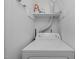 Close up of a white washing machine with shelving above in a well lit laundry room at 60 Justin Ct, Durham, NC 27705