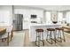 Modern kitchen with white cabinets, stainless steel appliances, quartz countertops and a large island with seating at 603 Silverado Sunset Loop, Wendell, NC 27591