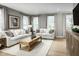 Spacious living room with large windows, plush white couches, modern decor, and a decorative center table at 603 Silverado Sunset Loop, Wendell, NC 27591