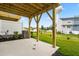 A covered back patio with wooden supports overlooks a grassy yard and neighboring homes, offering outdoor living space at 605 Silverado Sunset Loop, Wendell, NC 27591