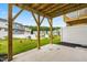 A concrete back patio with wooden supports overlooks a green yard and neighboring homes, providing outdoor space at 605 Silverado Sunset Loop, Wendell, NC 27591