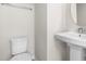 Half bathroom featuring a pedestal sink, toilet, and towel rack at 605 Silverado Sunset Loop, Wendell, NC 27591