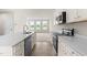 Bright open kitchen featuring a large island with sink and quartz countertops and stainless steel appliances at 605 Silverado Sunset Loop, Wendell, NC 27591