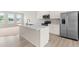 Bright kitchen featuring a large island with sink and quartz countertops and stainless steel appliances at 605 Silverado Sunset Loop, Wendell, NC 27591