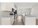 Bright open kitchen featuring a large island with sink and quartz countertops and stainless steel appliances at 605 Silverado Sunset Loop, Wendell, NC 27591