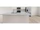Bright kitchen featuring a large island with sink and quartz countertops and stainless steel appliances at 605 Silverado Sunset Loop, Wendell, NC 27591