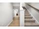 Hallway featuring carpeted stairs, light wood floors, and neutral walls at 607 Silverado Sunset Loop, Wendell, NC 27591