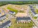 New construction aerial view with townhomes, green spaces and wooded areas in the neighborhood at 609 Silverado Sunset Loop, Wendell, NC 27591