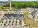 Aerial view of townhomes featuring well-manicured lawns, community water tower, and green spaces at 609 Silverado Sunset Loop, Wendell, NC 27591