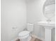 Modern powder room featuring a pedestal sink and a toilet with light wood floors at 609 Silverado Sunset Loop, Wendell, NC 27591