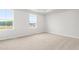 Bright empty bedroom with carpet and two windows allowing natural light at 609 Silverado Sunset Loop, Wendell, NC 27591