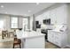 Modern kitchen with white cabinetry, stainless steel appliances, an island with seating, and a dining area at 609 Silverado Sunset Loop, Wendell, NC 27591