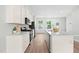 Bright kitchen boasts modern appliances, white cabinets, a spacious island and lots of sunlight at 609 Silverado Sunset Loop, Wendell, NC 27591