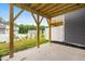 Concrete patio featuring wooden support beams and a view of the green surroundings at 609 Silverado Sunset Loop, Wendell, NC 27591
