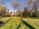 A grassy backyard provides a serene space with mature trees casting shadows at 610 Peele St, Burlington, NC 27215