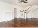 Bright living room features dark hardwood floors, a staircase with wooden accents, and fireplace at 610 Peele St, Burlington, NC 27215