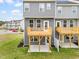 Gray townhome with wooden decks, ground patios, and a well-maintained lawn at 611 Silverado Sunset Loop, Wendell, NC 27591