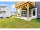 View of backyard with a concrete patio, wooden deck, green lawn and a grey home at 611 Silverado Sunset Loop, Wendell, NC 27591