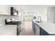 Contemporary kitchen with stainless steel appliances, island with sink, and abundant natural light from large windows at 611 Silverado Sunset Loop, Wendell, NC 27591