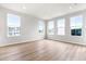 Bright and airy living room with large windows, neutral walls, and wood-look floors at 611 Silverado Sunset Loop, Wendell, NC 27591