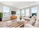 Bright living room with stylish furniture, modern TV, and large windows offering natural light at 611 Silverado Sunset Loop, Wendell, NC 27591
