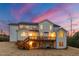 Rear view of the home showcasing the deck, patio, and ample outdoor space at twilight at 7100 Hasentree Club Dr, Wake Forest, NC 27587