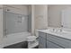 Modern bathroom with a shower-tub combo, gray tile, and a double sink vanity at 7100 Hasentree Club Dr, Wake Forest, NC 27587