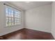 Cozy bedroom with hardwood floors, neutral paint, and a large window providing natural light at 7100 Hasentree Club Dr, Wake Forest, NC 27587