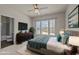 Stylishly staged bedroom featuring a bed with accent pillows, a mounted TV, and windows overlooking the neighborhood at 7100 Hasentree Club Dr, Wake Forest, NC 27587