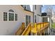 View of the stairs leading up to the spacious wooden deck with sliding glass door access at 7100 Hasentree Club Dr, Wake Forest, NC 27587