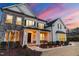 Beautiful two-story home with stone accents, well-manicured landscaping, and elegant lighting at 7100 Hasentree Club Dr, Wake Forest, NC 27587