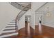 Grand foyer with a curved staircase, hardwood floors, and elegant lighting at 7100 Hasentree Club Dr, Wake Forest, NC 27587