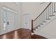 Bright foyer with hardwood floors and a staircase with a decorative iron railing at 7100 Hasentree Club Dr, Wake Forest, NC 27587