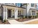 Elegant front entrance with white columns, stone accents, and a walkway leading to the front door at 7100 Hasentree Club Dr, Wake Forest, NC 27587
