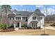 Beautiful two-story home with stone and white shingle siding, black shutters, and a well-manicured lawn at 7100 Hasentree Club Dr, Wake Forest, NC 27587