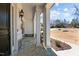 Inviting front porch with stone flooring, white columns, and a view of the landscaped yard at 7100 Hasentree Club Dr, Wake Forest, NC 27587