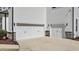 Spacious three-car garage with white doors and stone accents on a two-story home at 7100 Hasentree Club Dr, Wake Forest, NC 27587
