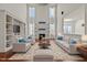 Staged living room with seating, a fireplace, and tall windows creating an inviting space at 7100 Hasentree Club Dr, Wake Forest, NC 27587