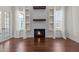 Living room showcasing the fireplace, built-in shelving, and natural light from the adjacent windows at 7100 Hasentree Club Dr, Wake Forest, NC 27587