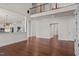 Open-concept living area with hardwood floors, view of the kitchen, and staircase to the upper level at 7100 Hasentree Club Dr, Wake Forest, NC 27587