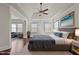 Spacious main bedroom featuring hardwood floors, tray ceiling, and a cozy sitting area at 7100 Hasentree Club Dr, Wake Forest, NC 27587