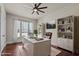 Bright office features a large window, hardwood floors, white desk, shelving, and a comfortable leather chair at 7100 Hasentree Club Dr, Wake Forest, NC 27587