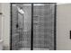 Close up of a modern shower with black framed glass door and black and white patterned tile at 7100 Hasentree Club Dr, Wake Forest, NC 27587