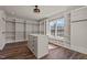 Spacious walk-in closet with custom shelves, hanging rods, center island and a large window for natural light at 7100 Hasentree Club Dr, Wake Forest, NC 27587