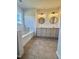 Bathroom featuring a dual sink vanity, tile floors, modern lighting fixtures and round mirrors at 723 Whitt Town Rd Rd, Roxboro, NC 27574