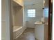 Well-lit bathroom with a tub, vanity, and large window; freshly renovated at 736 Core Rd Rd, Dunn, NC 28334
