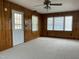 Comfortable living room with wood paneling, three windows, plush carpeting, and a ceiling fan at 736 Core Rd Rd, Dunn, NC 28334