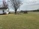 Large, grassy yard features mature trees, a wishing well, and open space at 736 Core Rd Rd, Dunn, NC 28334
