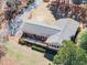 An aerial view of a charming home with a spacious backyard, wooden deck, mature trees, and a private driveway at 7516 Mourning Dove Dr, Sanford, NC 27332